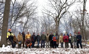 A group of people facing the camera in a forest in winter
