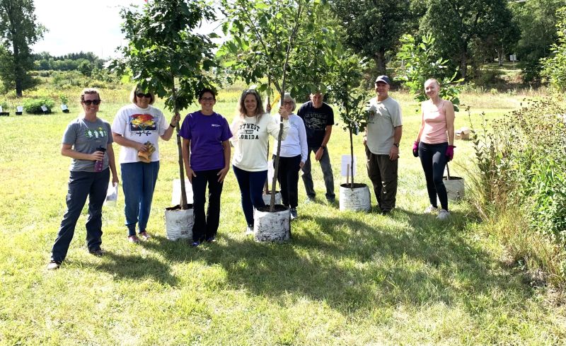 A group of people standing by native trees.