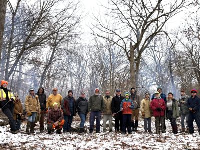 A group of people facing the camera in a forest in winter