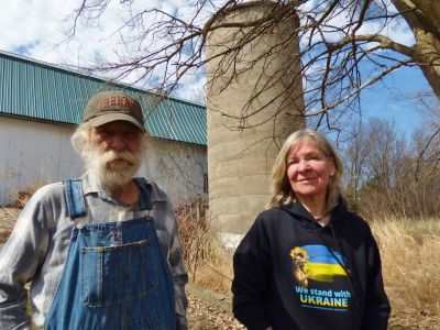 Sister and brother standing by a barn.