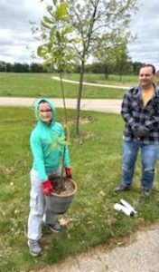 A child holding a potted tree.