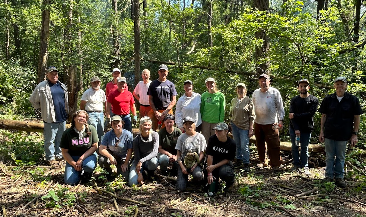 A group posting for a photo in the woods