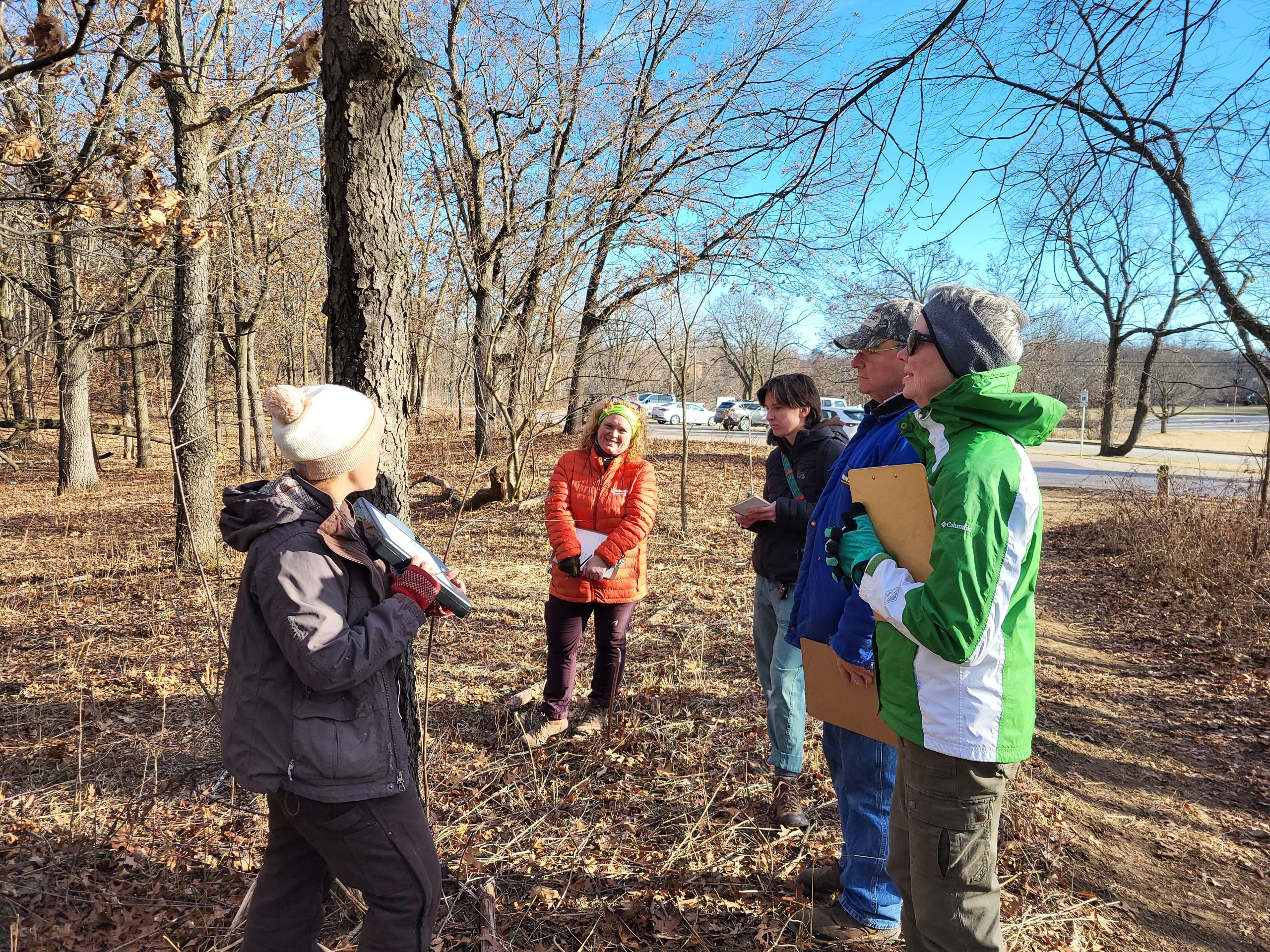 A group of people with an instructor learning about trees.