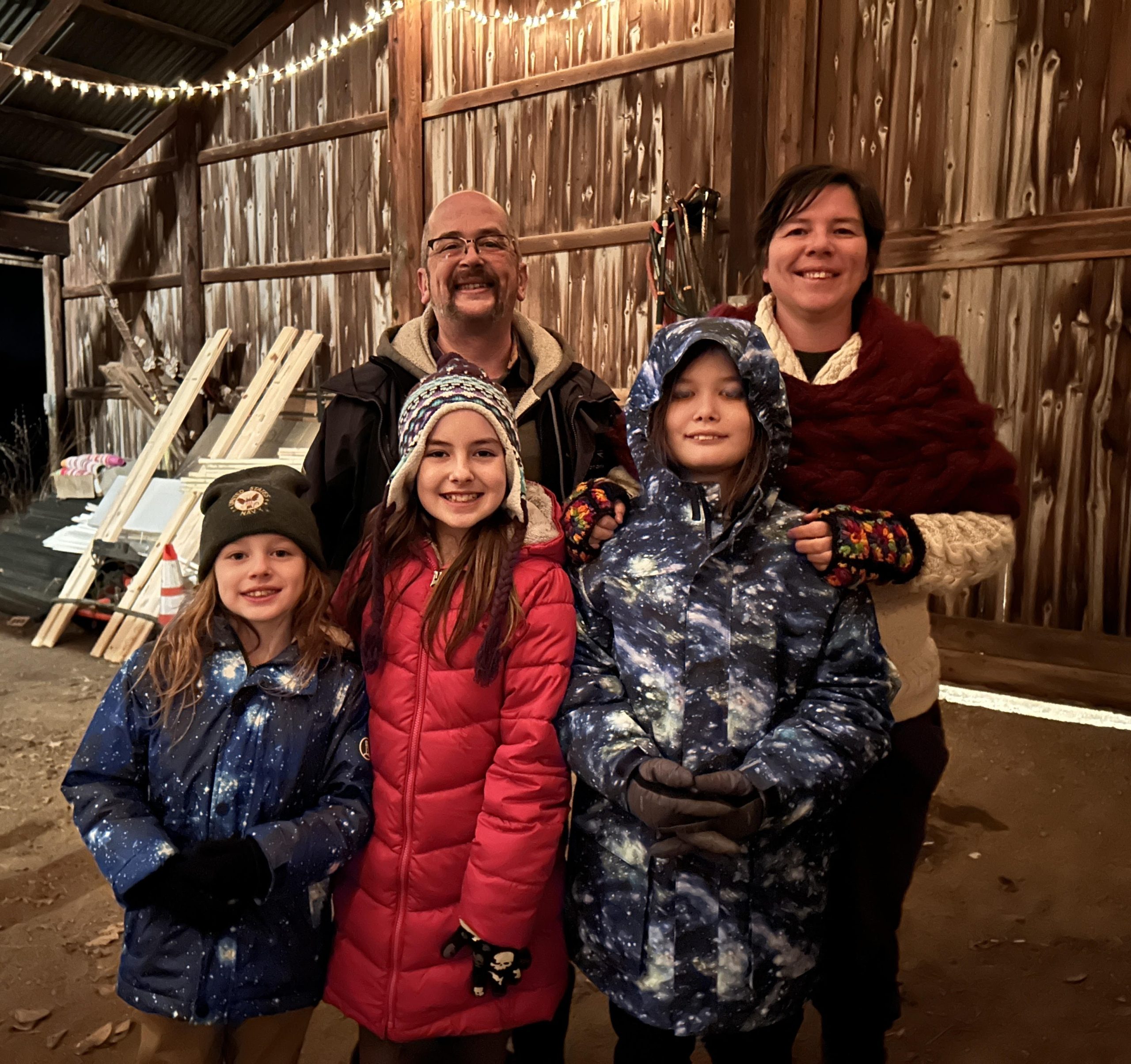 A family in winter clothing in a barn in Woodstock, IL