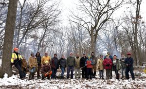 A group of people facing the camera in a forest in winter