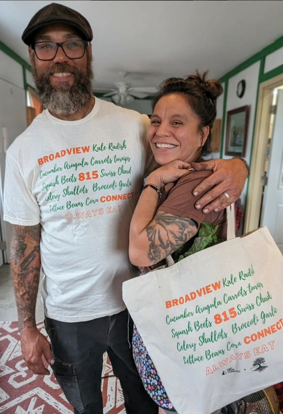 A couple posing with t-shirts and tote bag
