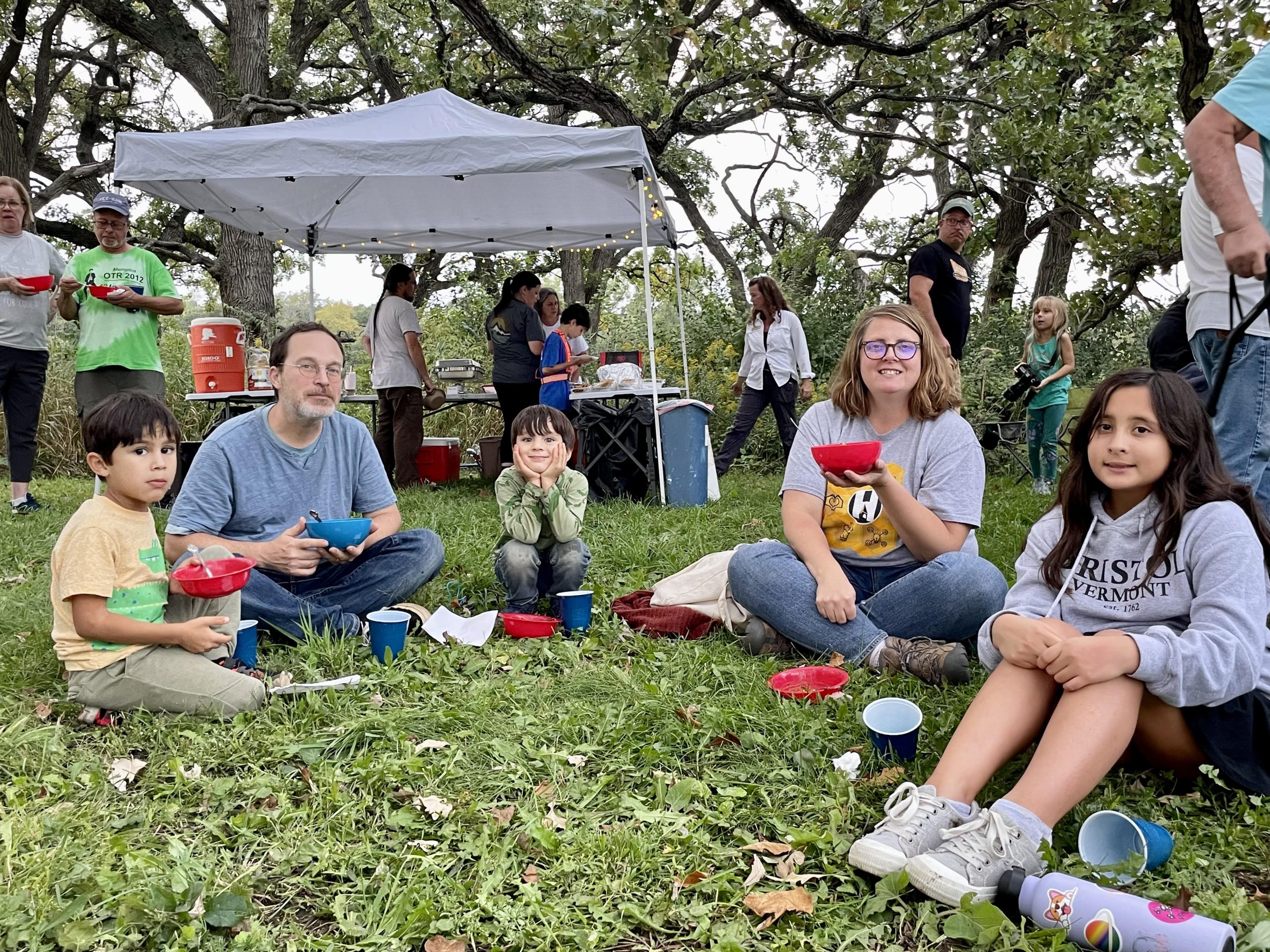 A family sitting in a circle at an event.