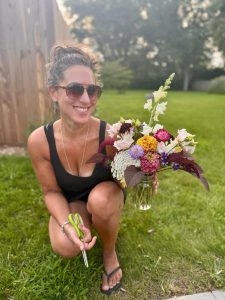 TLC member Andrea Arrigo with a bouquet of flowers in her yard.