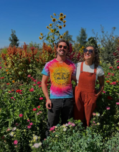 Derek Kessler and Emily Jones standing in their farm field.