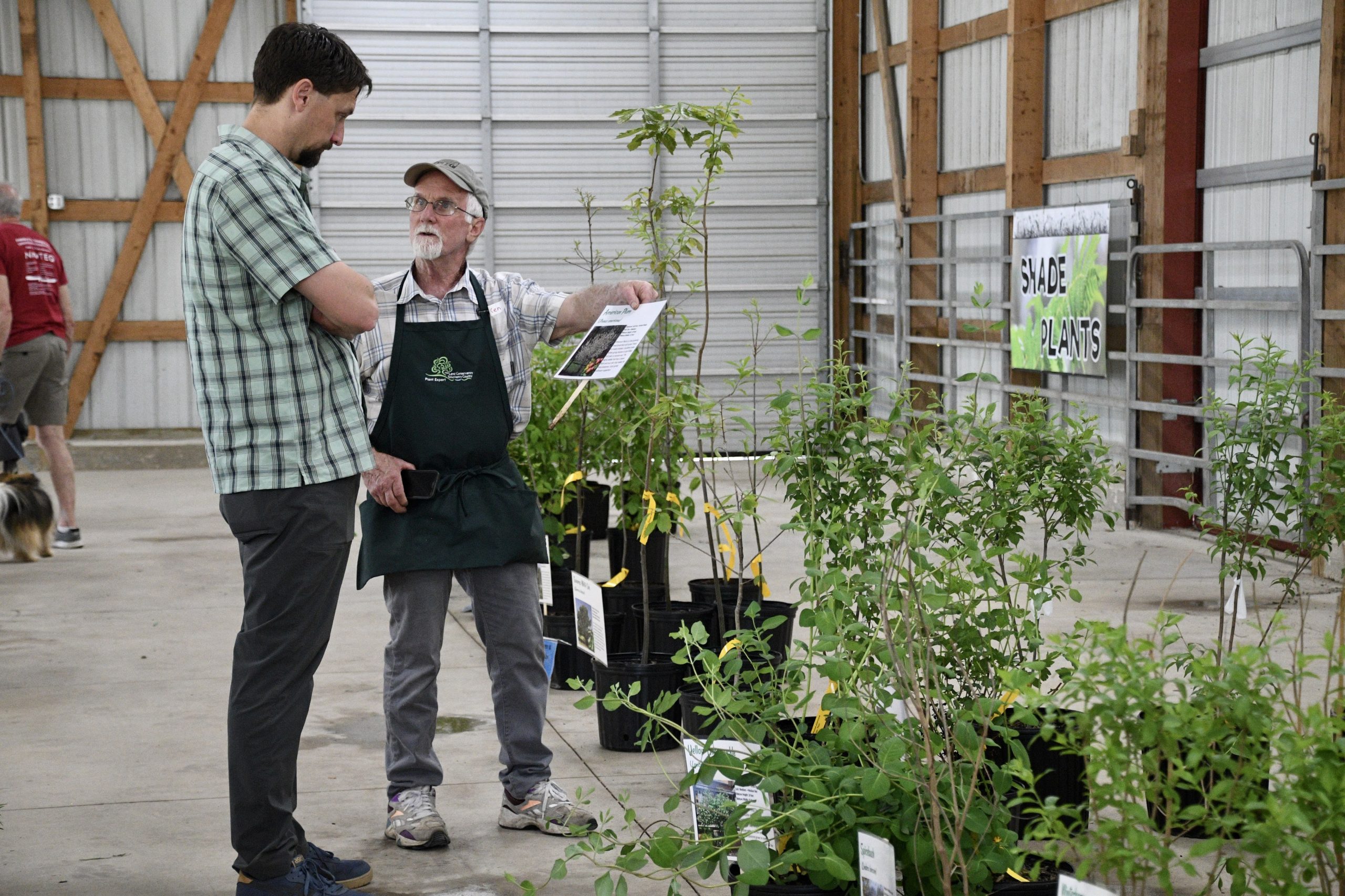 A man advising a customer at TLC's Native Plant Sale
