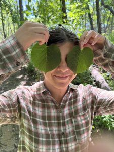 TLC intern Jazzy holding 2 leaves up to her eyes