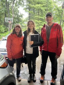 Three people smiling in a driveway after a Conservation@Home visit.