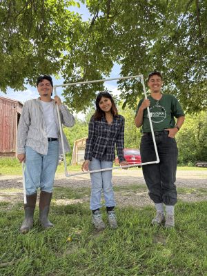 Three interns holding up a pvc quadrat