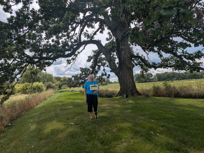 A woman standing under an oak tree