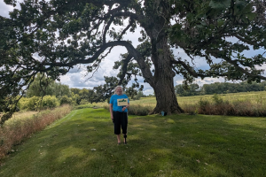 A woman standing under an oak tree