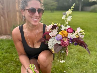 TLC member Andrea Arrigo with a bouquet of flowers in her yard.
