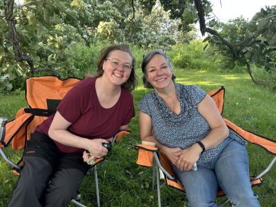 Two women in lawn chairs outdoors.