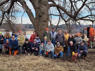 A group posing in front of an oak tree in winter.
