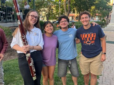 A group of four young people, one holding a clarinet