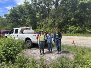 Ecological interns standing by a work truck.